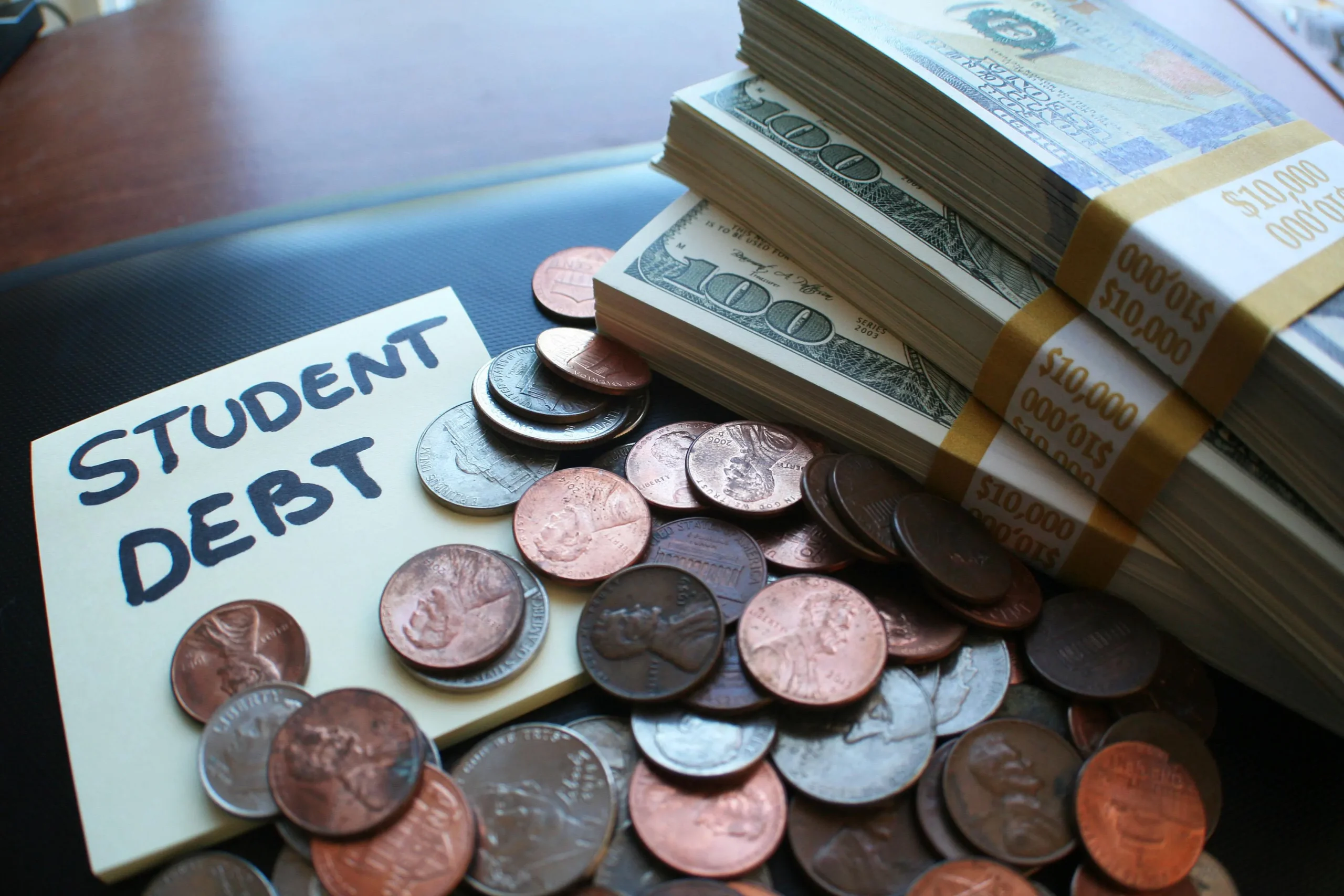 Student loan paperwork with a calculator, pen, and financial documents on a desk, symbolizing education financing.

